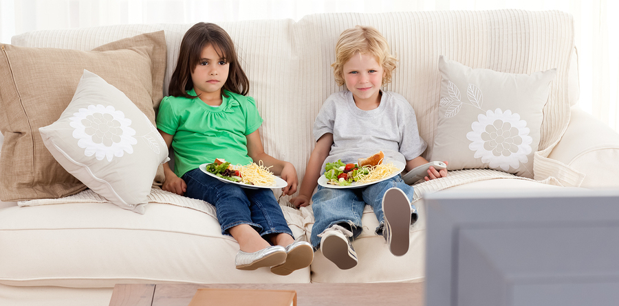 Cute Brother And Sister Having Dinner On The Sofa
